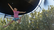Charger l'image dans la visionneuse de galerie, young girl jumping high on a trampoline with sun shade